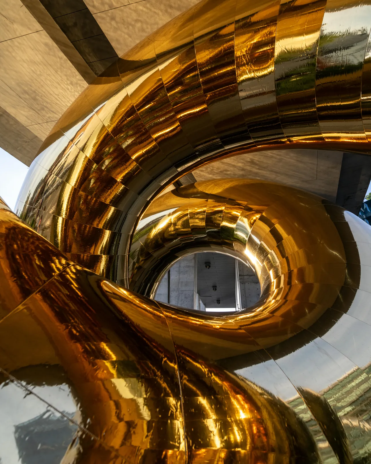 Nahaufnahme der goldenen, spiegelnd polierten Windungen der Bulgari Serpenti Installation
