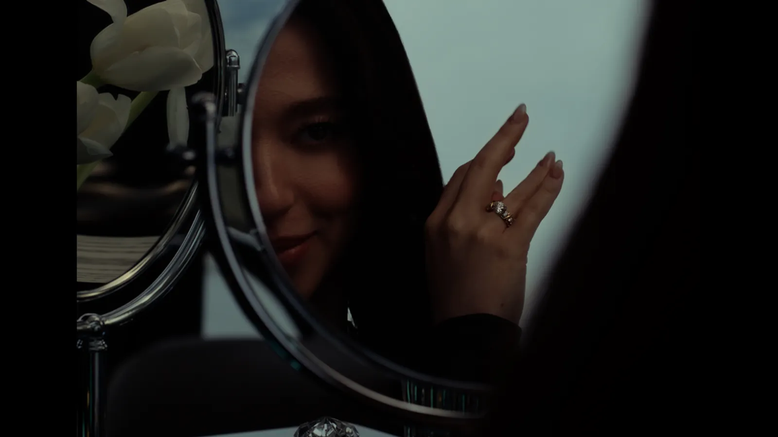 Szene aus dem Kampagnenfilm von Tiffany & Co.: Mikey Madison im Spiegel, am Finger der Ring Sixteen Stone by Tiffany
