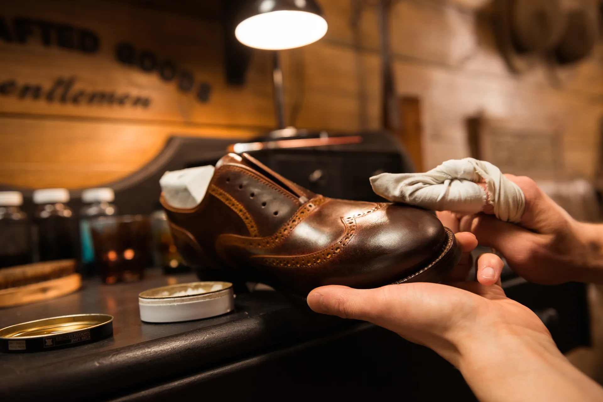 Ein handgefertigter Herrenschuh aus Kalbsleder auf einem hölzernen Leisten in einer Schuhmacherwerkstatt