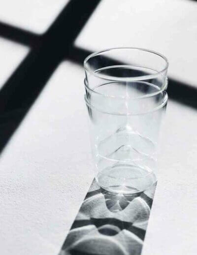 Ein Glas Wasser mit einem Schatten darauf.