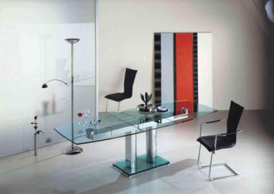 Ein Esstisch und Stühle aus Glas in einem Raum.