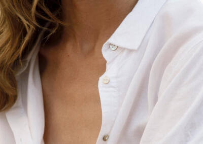 Eine Frau in einem weißen Hemd posiert für ein Foto.