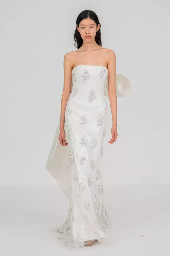 Ein Model, das ein trägerloses Hochzeitskleid auf dem Laufsteg trägt.