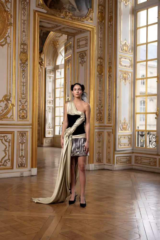 Eine Frau steht in einem reich verzierten Raum und trägt ein Kleid.